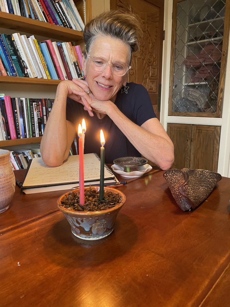 Caffyn looking contemplatively at three burning candles